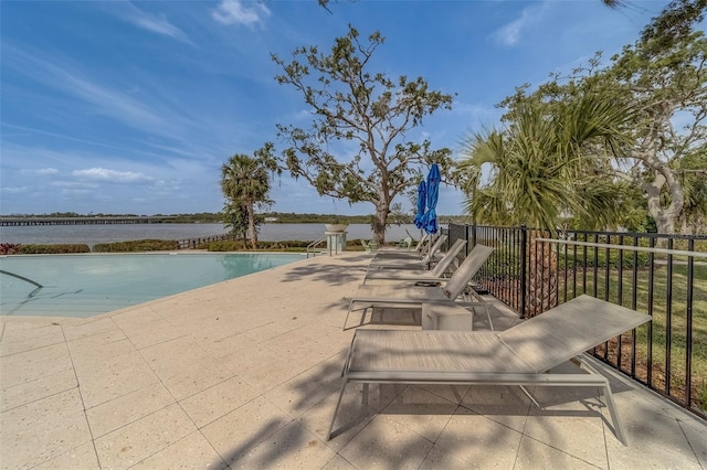 view of pool featuring a fenced in pool, a water view, and a patio area