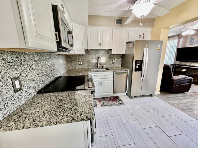 kitchen with white cabinets, ceiling fan, appliances with stainless steel finishes, a sink, and visible vents