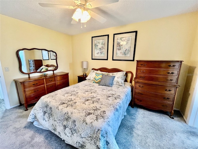 bedroom with a textured ceiling, carpet, and ceiling fan