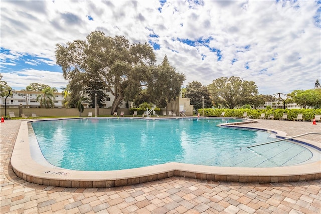 pool with a patio and fence
