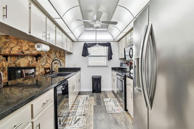 8225 Medford Dr, Port Richey, FL 34668 - kitchen with stainless steel appliances, a sink, dark wood-style floors, a ceiling fan, and white cabinetry