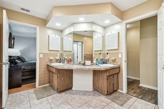 8225 Medford Dr, Port Richey, FL 34668 - full bathroom with tile walls, tile patterned floors, double vanity, and wainscoting