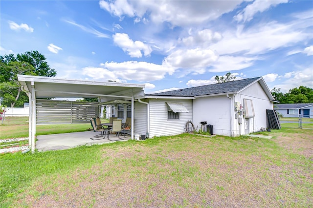 back of property with fence, a patio, and a lawn