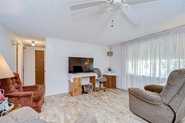 living area featuring a ceiling fan and a textured ceiling
