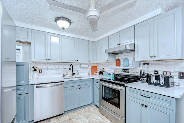 kitchen featuring a sink, appliances with stainless steel finishes, under cabinet range hood, and light countertops