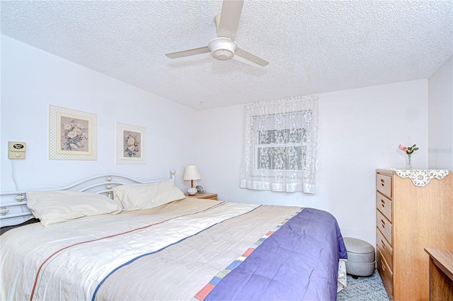 carpeted bedroom with ceiling fan and a textured ceiling