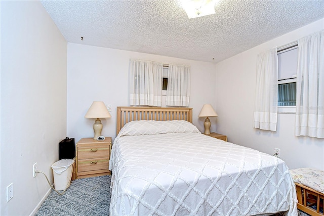 bedroom featuring carpet flooring and a textured ceiling