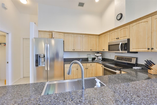 6332 35th Avenue Cir E, Palmetto, FL 34221 - kitchen featuring appliances with stainless steel finishes, light brown cabinetry, a sink, a high ceiling, and dark stone countertops