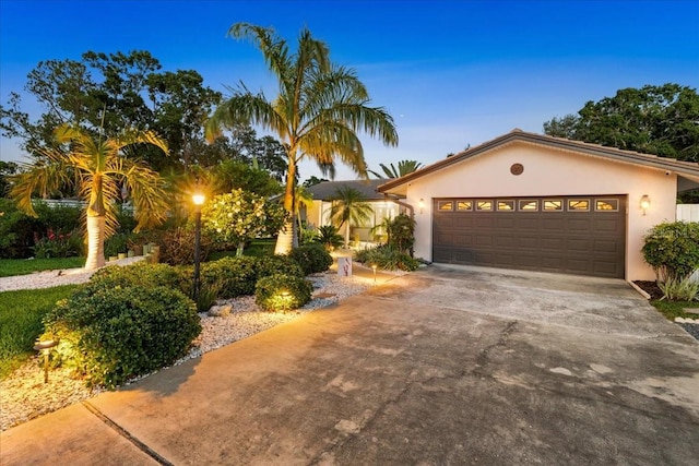 view of front of property with stucco siding, an attached garage, and concrete driveway