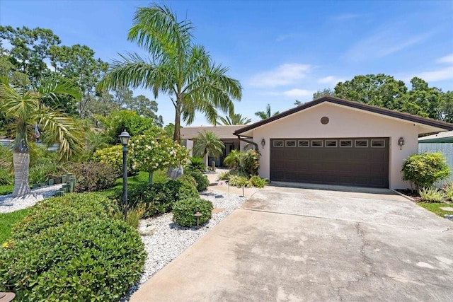 ranch-style house featuring stucco siding, an attached garage, and driveway