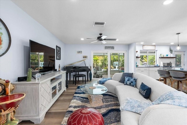 living area with recessed lighting, light wood finished floors, and a ceiling fan