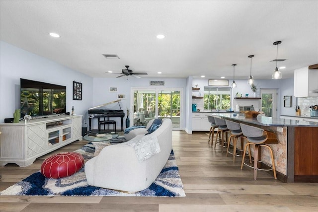 living room featuring light wood-style floors, recessed lighting, and a ceiling fan