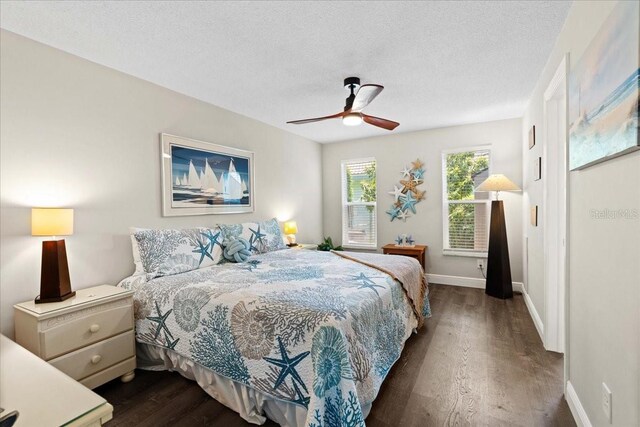 bedroom featuring dark wood finished floors, baseboards, a textured ceiling, and ceiling fan