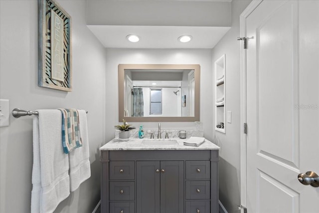 full bath featuring vanity and baseboards