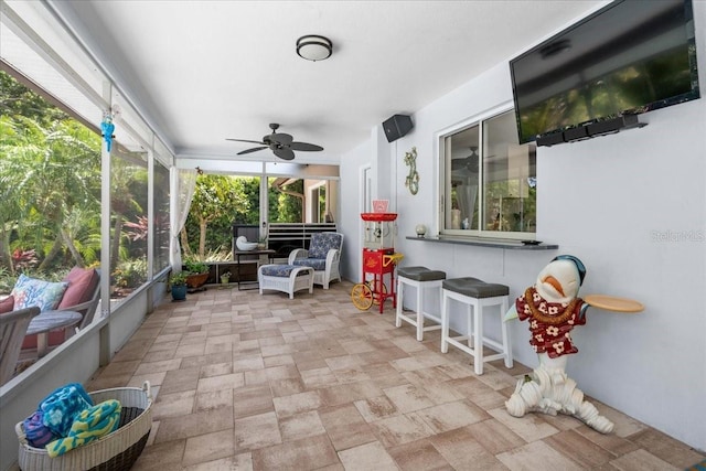 sunroom featuring a ceiling fan