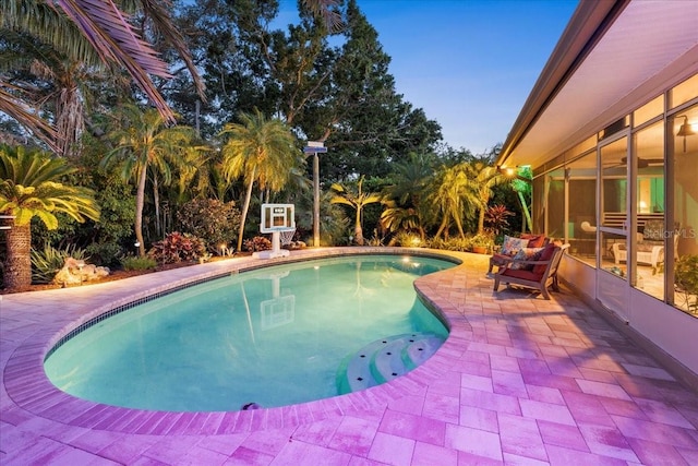 outdoor pool featuring a sunroom and a patio