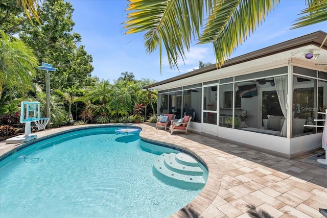 outdoor pool featuring a sunroom and a patio area
