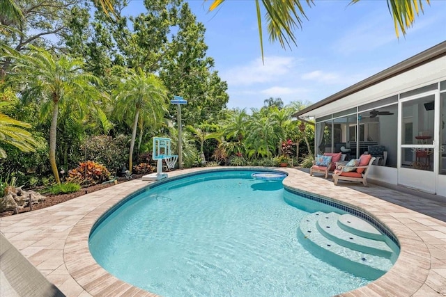swimming pool with a sunroom, a patio, and a ceiling fan