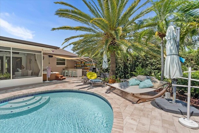 swimming pool featuring a patio area and a sunroom