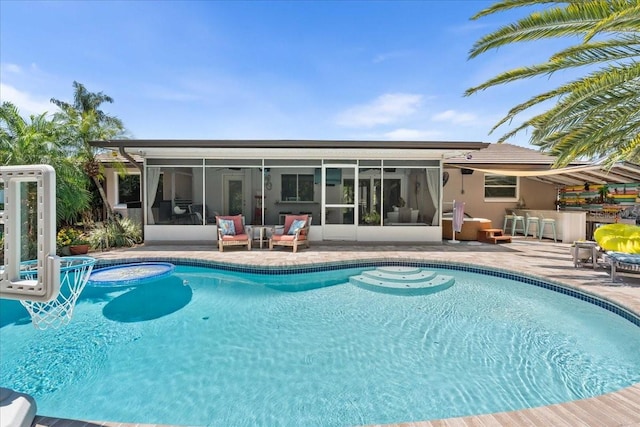 swimming pool featuring a sunroom and a patio