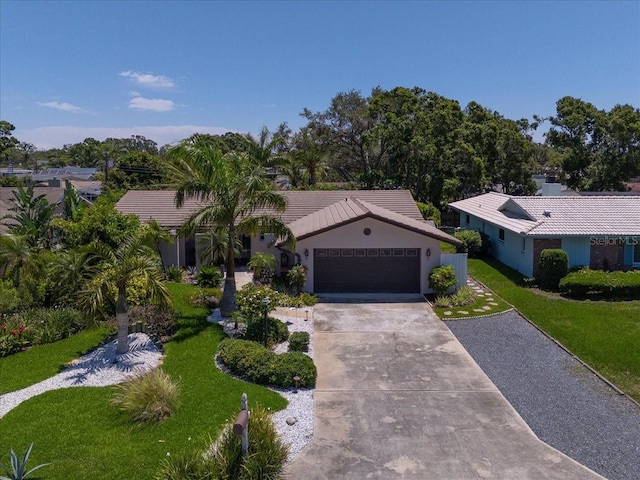 single story home with driveway, a garage, a front yard, a tile roof, and stucco siding