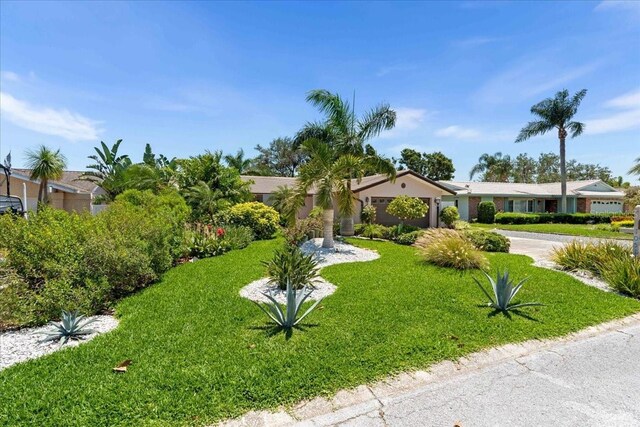 view of front of house with driveway, a front yard, and a garage
