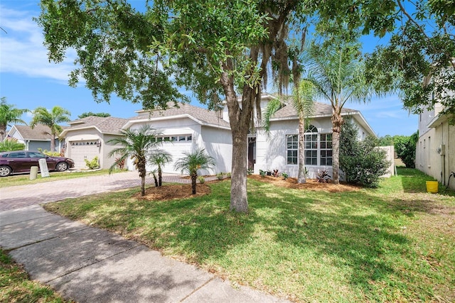 8407 Hunters Fork Loop, Ruskin, FL 33573 - ranch-style home with an attached garage, stucco siding, driveway, and a front yard
