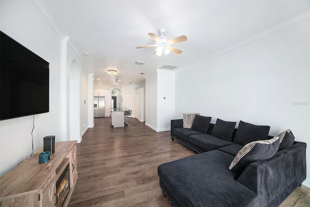 8407 Hunters Fork Loop, Ruskin, FL 33573 - living area featuring visible vents, crown molding, ceiling fan, dark wood-style flooring, and arched walkways