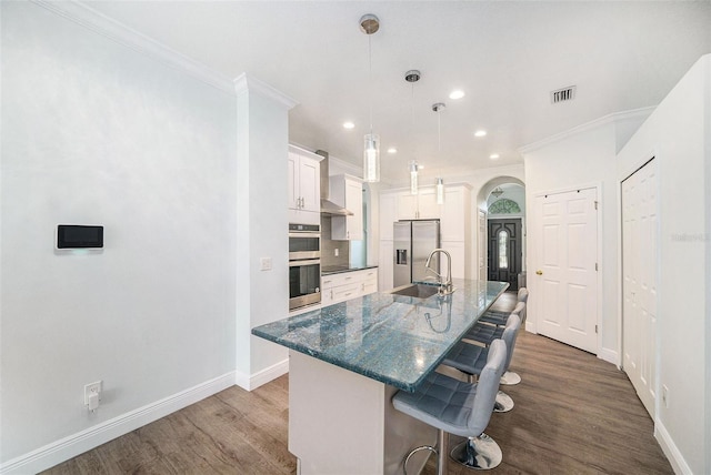 8407 Hunters Fork Loop, Ruskin, FL 33573 - kitchen with visible vents, dark wood finished floors, a kitchen bar, arched walkways, and baseboards