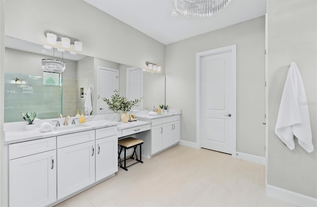 bathroom with a sink, baseboards, a tile shower, and two vanities