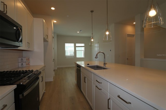 kitchen featuring tasteful backsplash, a sink, stainless steel appliances, recessed lighting, and white cabinetry