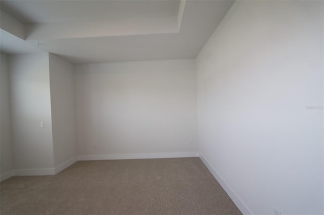 unfurnished room featuring baseboards and light carpet