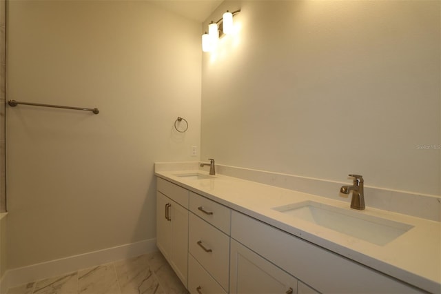bathroom featuring double vanity, baseboards, a sink, and marble finish floor