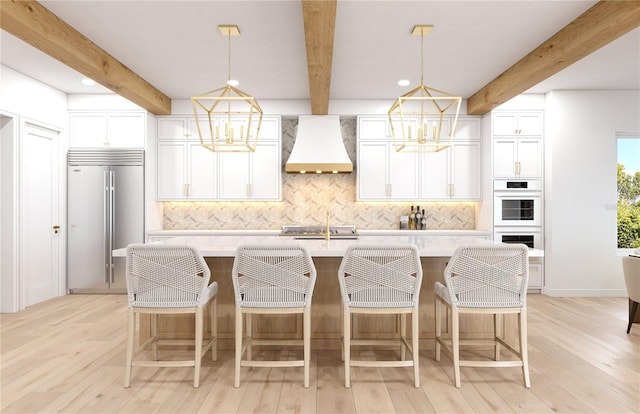 4 W Spanish Main St, Tampa, FL 33609 - kitchen with custom range hood, stainless steel built in refrigerator, a chandelier, beamed ceiling, and backsplash