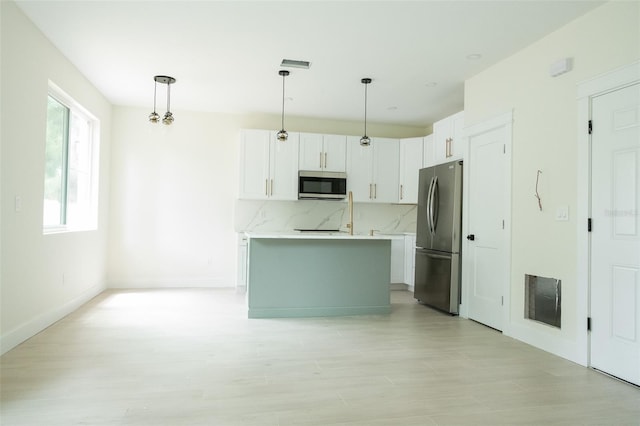 12484 Cross St, Largo, FL 33773 - kitchen featuring appliances with stainless steel finishes, white cabinetry, decorative light fixtures, and baseboards