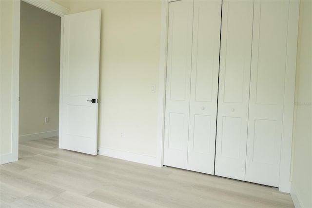 12484 Cross St, Largo, FL 33773 - unfurnished bedroom featuring light wood-style flooring, baseboards, and a closet