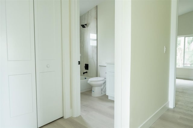 12484 Cross St, Largo, FL 33773 - full bath featuring  shower combination, toilet, wood finished floors, and baseboards