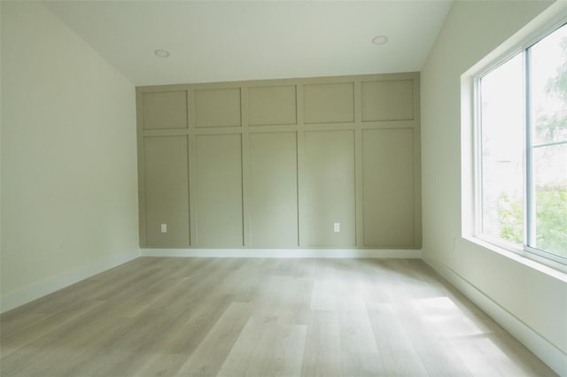 12484 Cross St, Largo, FL 33773 - unfurnished bedroom featuring light wood-type flooring, lofted ceiling, and baseboards