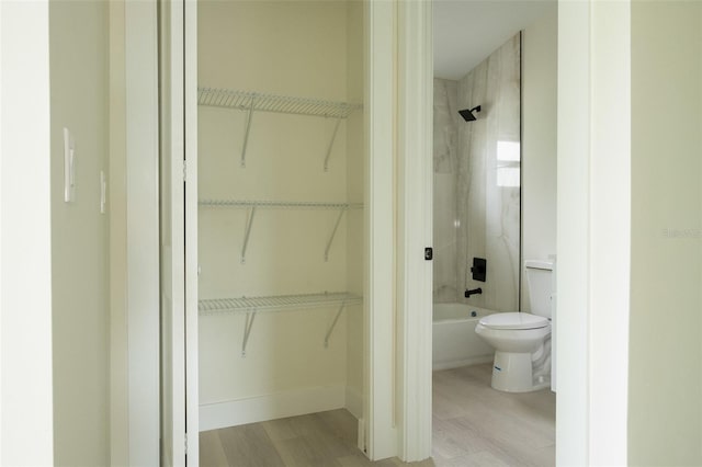 12484 Cross St, Largo, FL 33773 - full bathroom with wood finished floors, toilet, bathing tub / shower combination, and a walk in closet