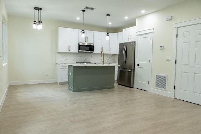 12484 Cross St, Largo, FL 33773 - kitchen with appliances with stainless steel finishes, light countertops, decorative backsplash, recessed lighting, and light wood finished floors