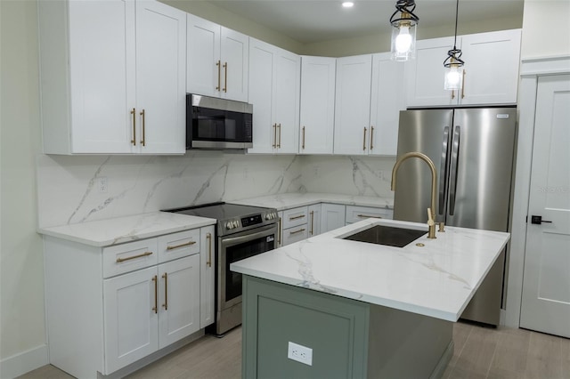 12484 Cross St, Largo, FL 33773 - kitchen featuring stainless steel appliances, decorative backsplash, an island with sink, and light stone counters