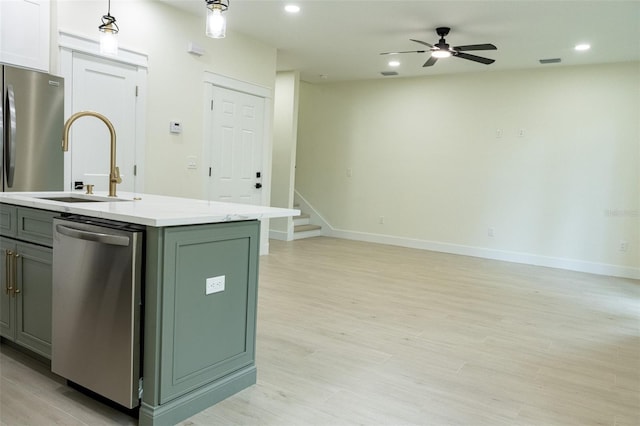 12484 Cross St, Largo, FL 33773 - kitchen featuring stainless steel appliances, open floor plan, light countertops, light wood-style floors, and decorative light fixtures