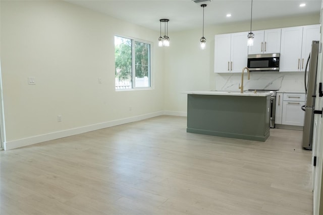 12484 Cross St, Largo, FL 33773 - kitchen with appliances with stainless steel finishes, light wood-style floors, recessed lighting, hanging light fixtures, and white cabinetry