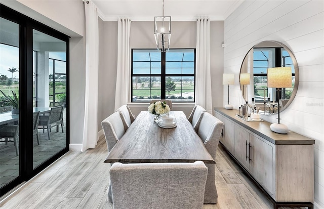 dining area with ornamental molding, a wealth of natural light, and light wood-style floors