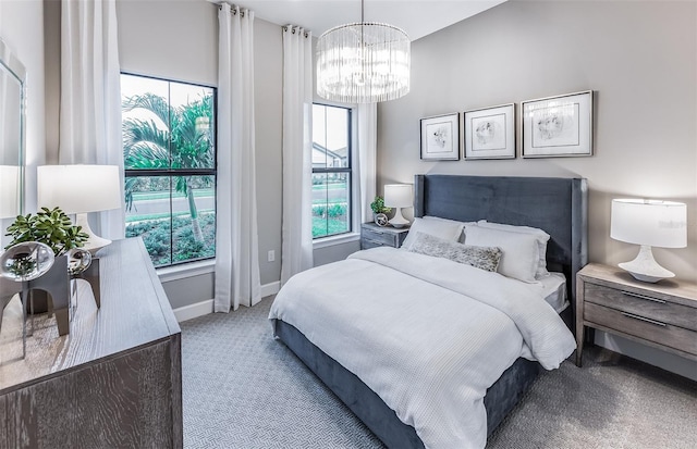 bedroom with baseboards, an inviting chandelier, and carpet