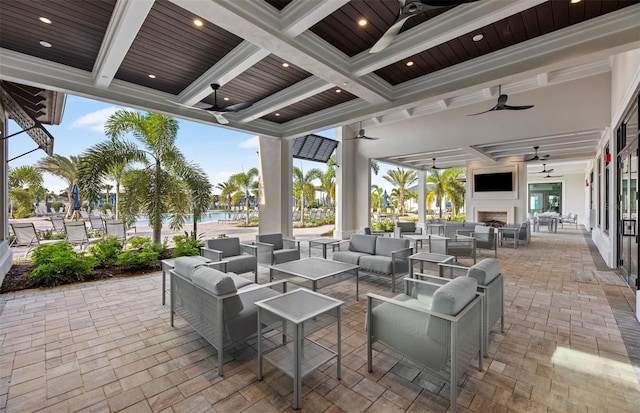 view of patio / terrace with a ceiling fan and an outdoor living space with a fireplace