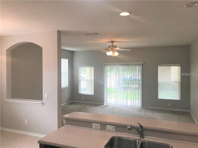 kitchen with a ceiling fan, baseboards, visible vents, and a sink