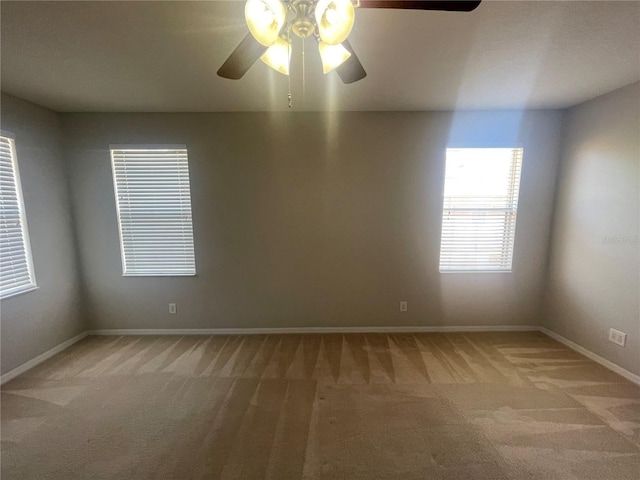 unfurnished room with baseboards, light carpet, and a ceiling fan