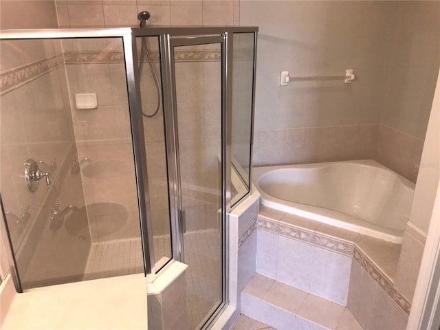 full bathroom with tile patterned flooring, a bath, and a stall shower