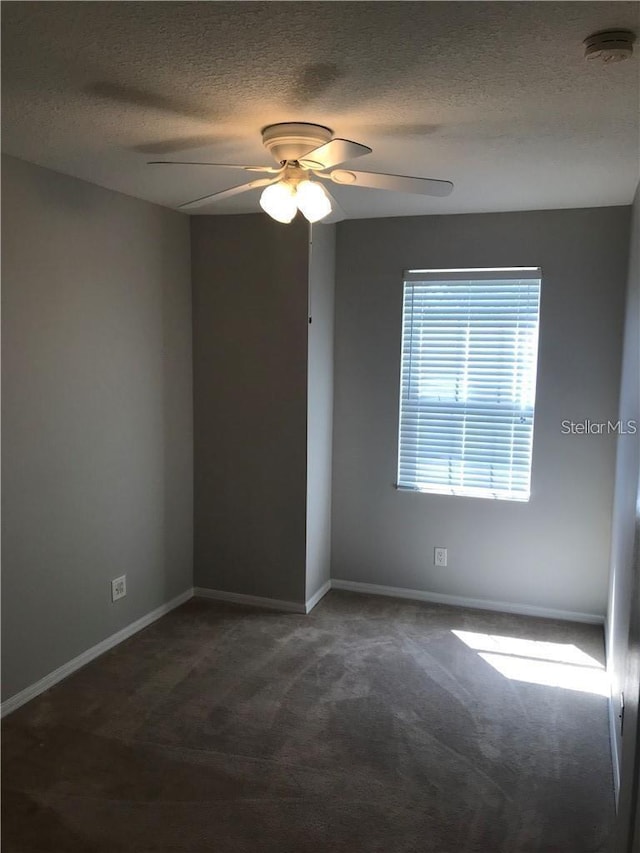 carpeted empty room with baseboards, a textured ceiling, and ceiling fan